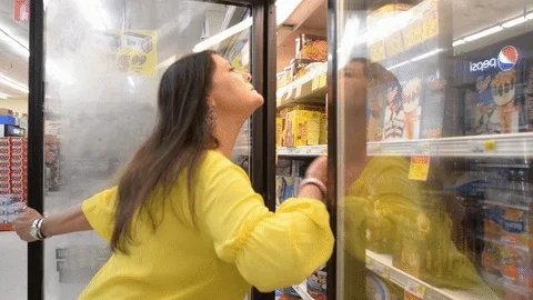 Woman fanning herself in grocery store fridge